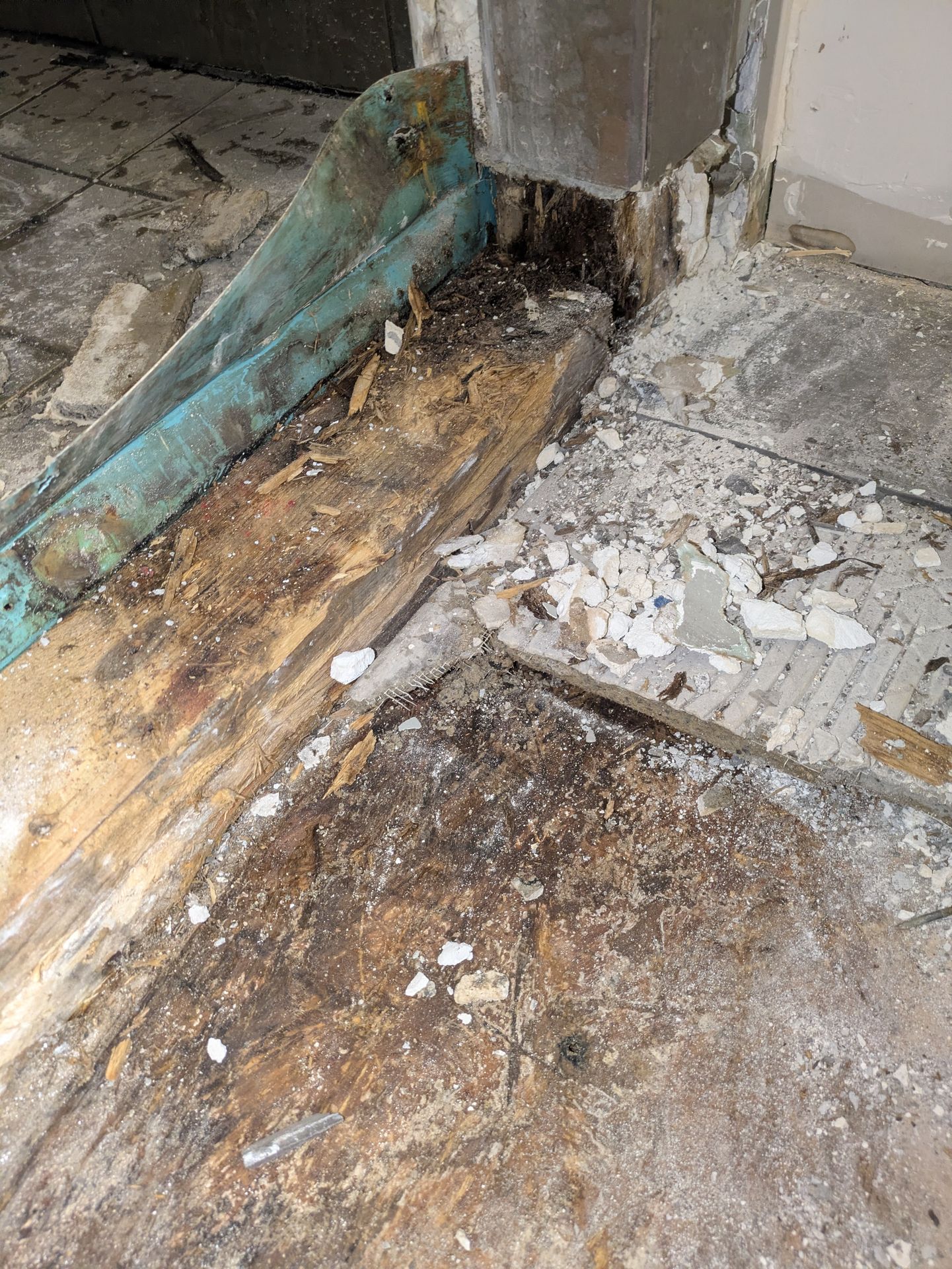 Removing water-damaged subfloor layers in a Normaltown bathroom